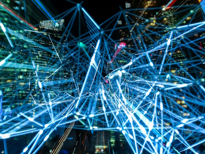 dynamiczna scena miejska ukazująca połączone świetlne smugi reprezentujące sieci komunikacji cyfrowej